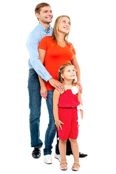 Couple with their girl child looking upwards. Copyspace. Family of three