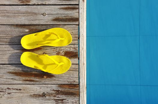 Yellow sandals by a swimming pool 