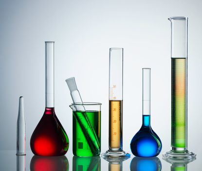 Chemical flasks with reagents over white background