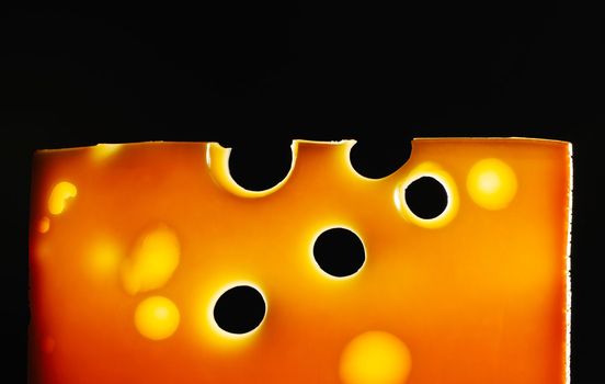 Swiss cheese over black background