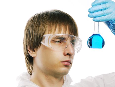 Scientist in protective wear and glasses looking at flask with reagent