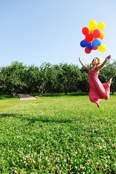 Girl jumping with balloons trying to fly