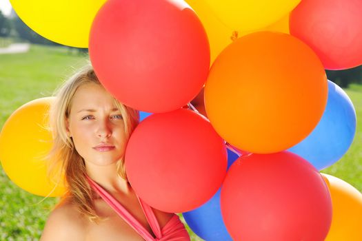 Girl holding balloons outdoors