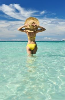 Girl on a tropical beach with hat