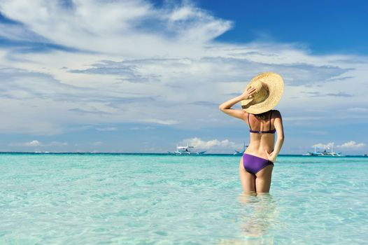 Girl on a tropical beach with hat