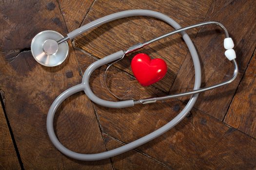 Heart with a stethoscope on a wooden surface