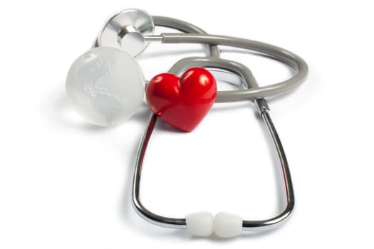 Stethoscope, red heart and global earth on white background