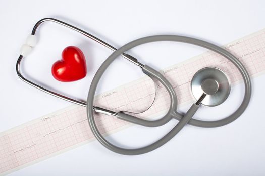 Stethoscope, red heart and cardiogram on white background