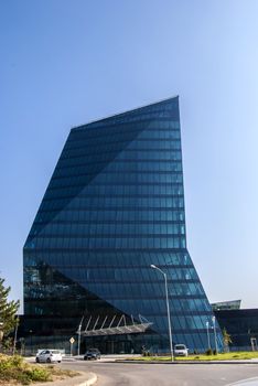 Contemporary office building side, blue glass windows general view