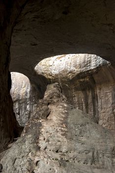 Big cave inside with hole light on ceiling