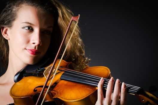 Woman with violin in dark room