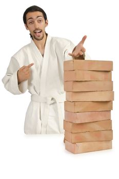 Karate man breaking bricks on white