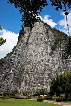 buddha image on the cliff, engraved by using laser beam wrote on the cliff of khoa chee chan in pattaya, thailand