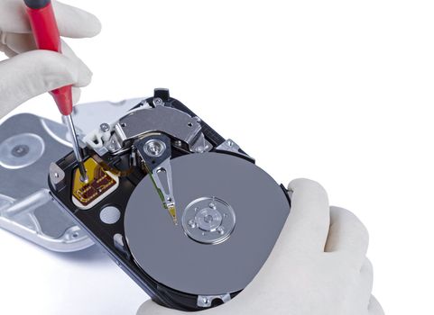 technician with open hard-disk and screwdriver in light background