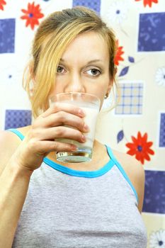 Portrait of sad young woman holding glass of milk