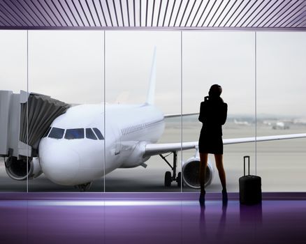 silhouette of businesswoman which expects flight aboard the plane at airport