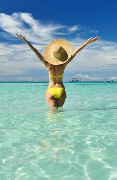 Girl on a tropical beach with outstretched arms