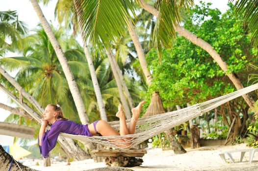 Woman in hammock on tropical beach