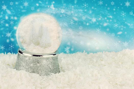 Snow globe with snow covered pine trees inside. Copy space available.