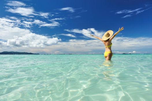 Girl on a tropical beach with outstretched arms