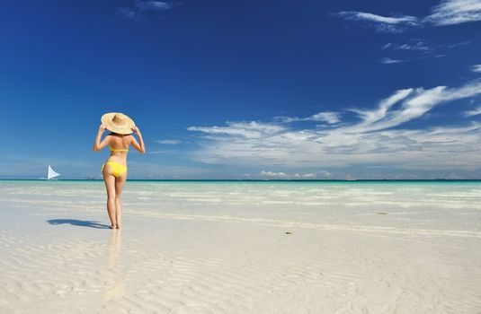 Girl on a tropical beach with hat