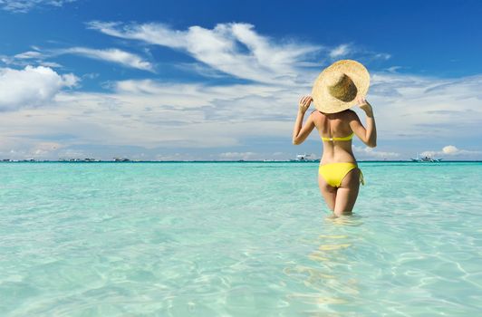 Girl on a tropical beach with outstretched arms