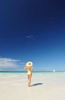 Girl on a tropical beach with hat