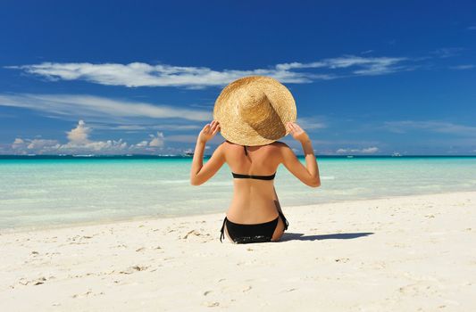 Girl on a tropical beach with hat