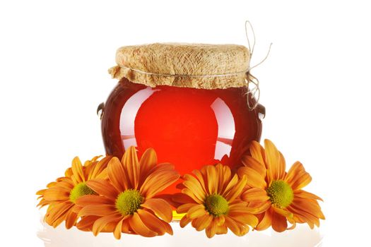 Jar of honey and flowers isolated over white