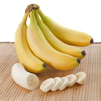 bunch of bananas  and slices on a wooden set