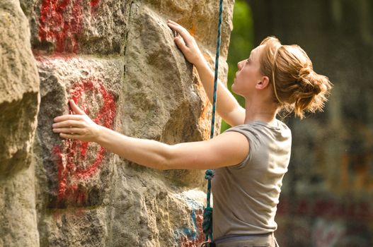 Female rock climber climbing a stone structure