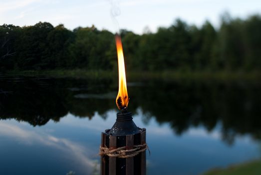 Tiki torch at the edge of a lake