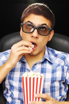 Young man watching movie in 3D glasses at cinema