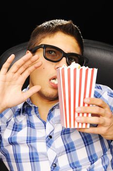 Young man watching movie in 3D glasses at cinema