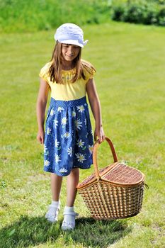 Girl with picnic basket on a meadow