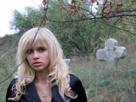 portrait of the beautiful blonde on an ancient cemetery