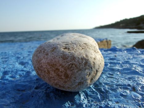 Greater pebble on a dark blue surface. Big picture