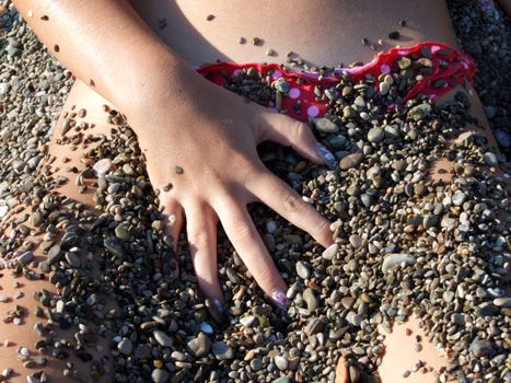 The sexual girl in a pebble on a beach