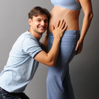 Happy pregnant couple over grey background