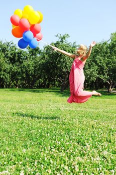 Girl jumping with balloons trying to fly