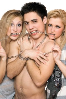 Two attractive girls and a guy in chains