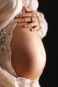Pregnant woman belly over black