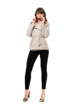 Sexy girl wearing a coat and black leggings. Isolated on white