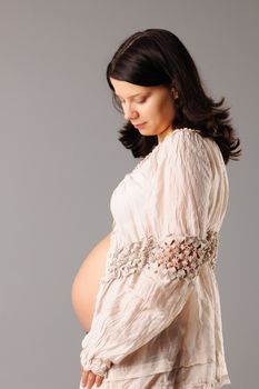 Portrait of a pregnant woman looking at her belly