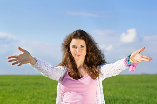 Portrait of happy young woman in a green field