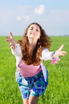 Portrait of cheerful young woman in a green field