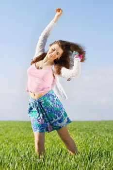 Cheerful nice young woman in a green field