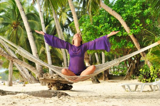 Woman in hammock on tropical beach