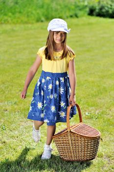 Girl with picnic basket on a meadow