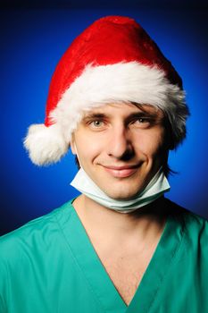 Surgeon with mask in Santa's hat smiling
